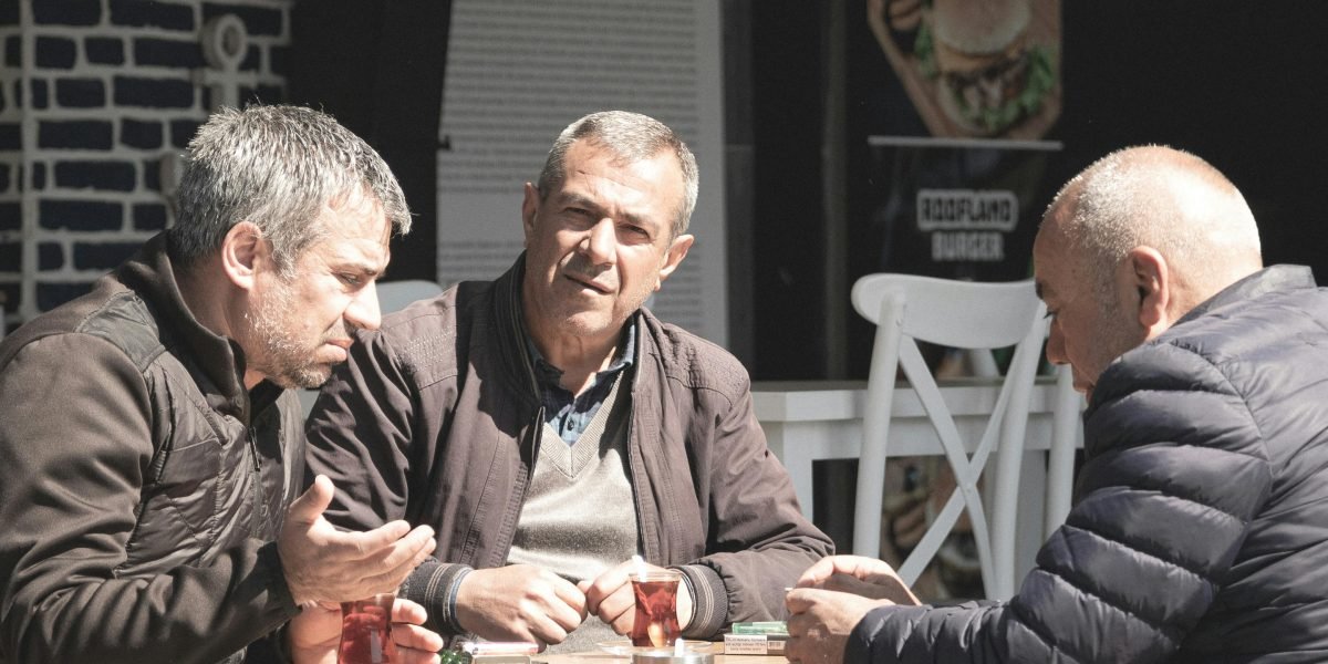 Men engaging in open conversation and connection, highlighting the importance of peer support networks.