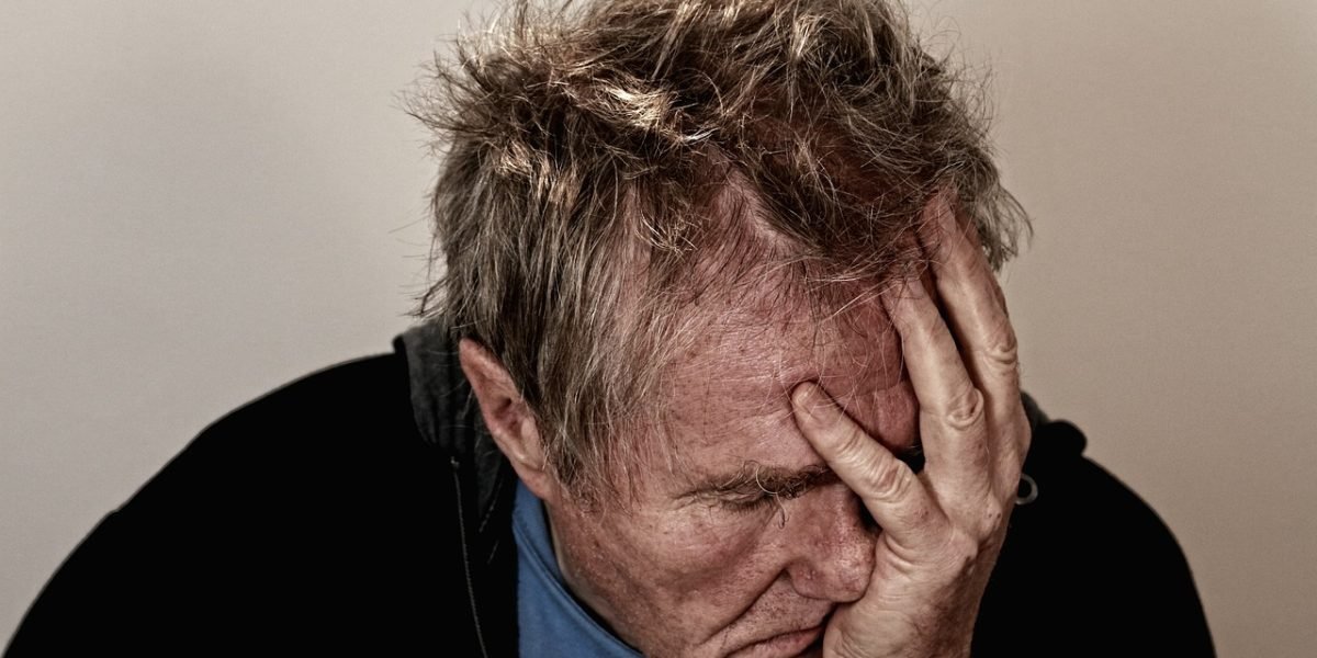 A man experiencing frustration and overwhelm, reflecting the internal struggle with irritability.