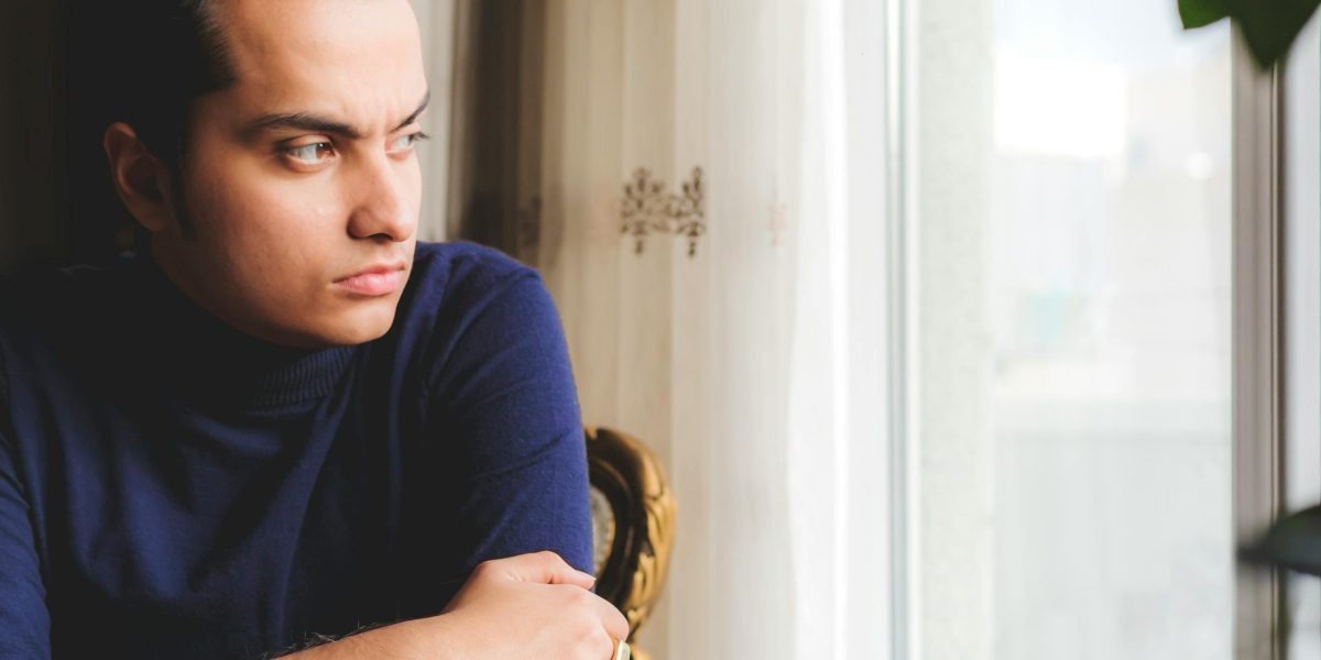 A man looking out, reflecting on feelings of isolation and loneliness.