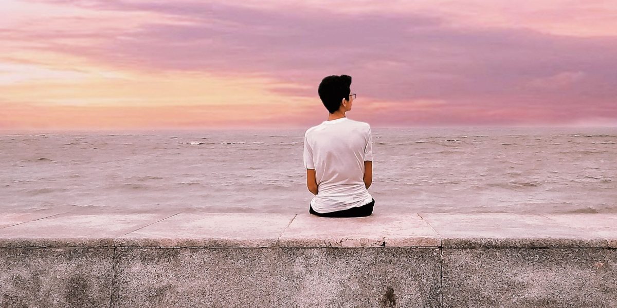 A man sits alone, lost in thought, representing the silent struggle of loneliness.
