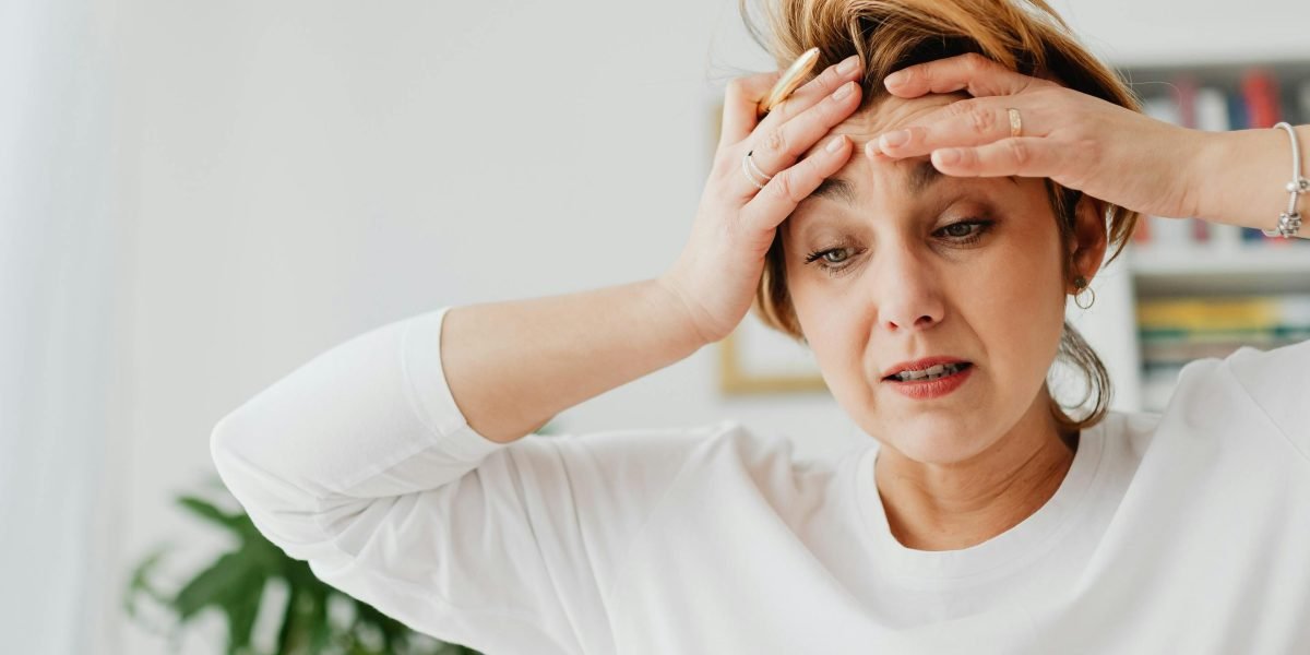 A person visibly stressed, symbolizing the common triggers and risk factors that can lead to anger issues.