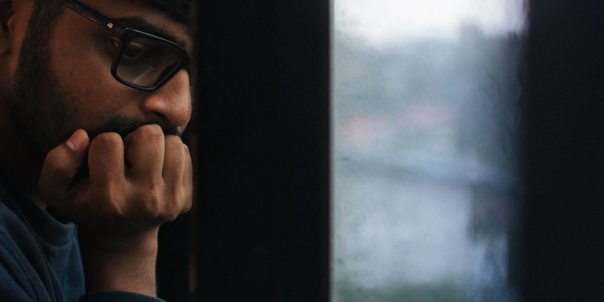 A man reflecting thoughtfully, perhaps considering the broader impact of loneliness or seeking connection.