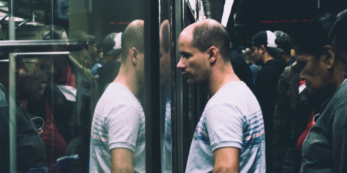 Despite being in a crowd, many men experience a profound sense of isolation and disconnection, reflecting the growing loneliness epidemic.