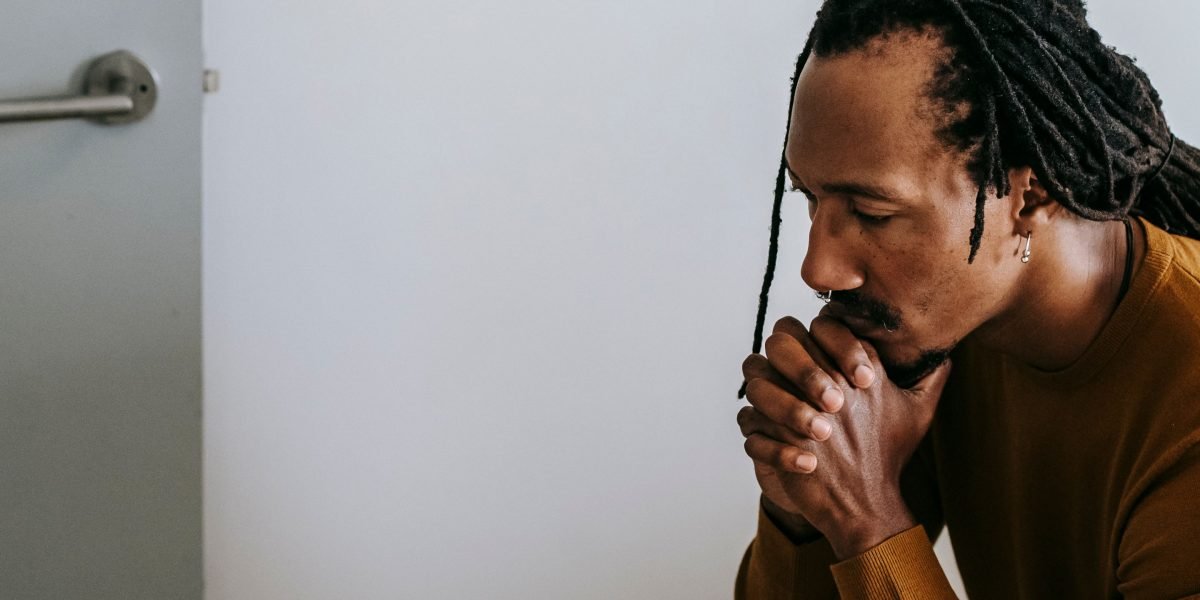 A man sitting alone, reflecting on feelings of isolation and disconnection.