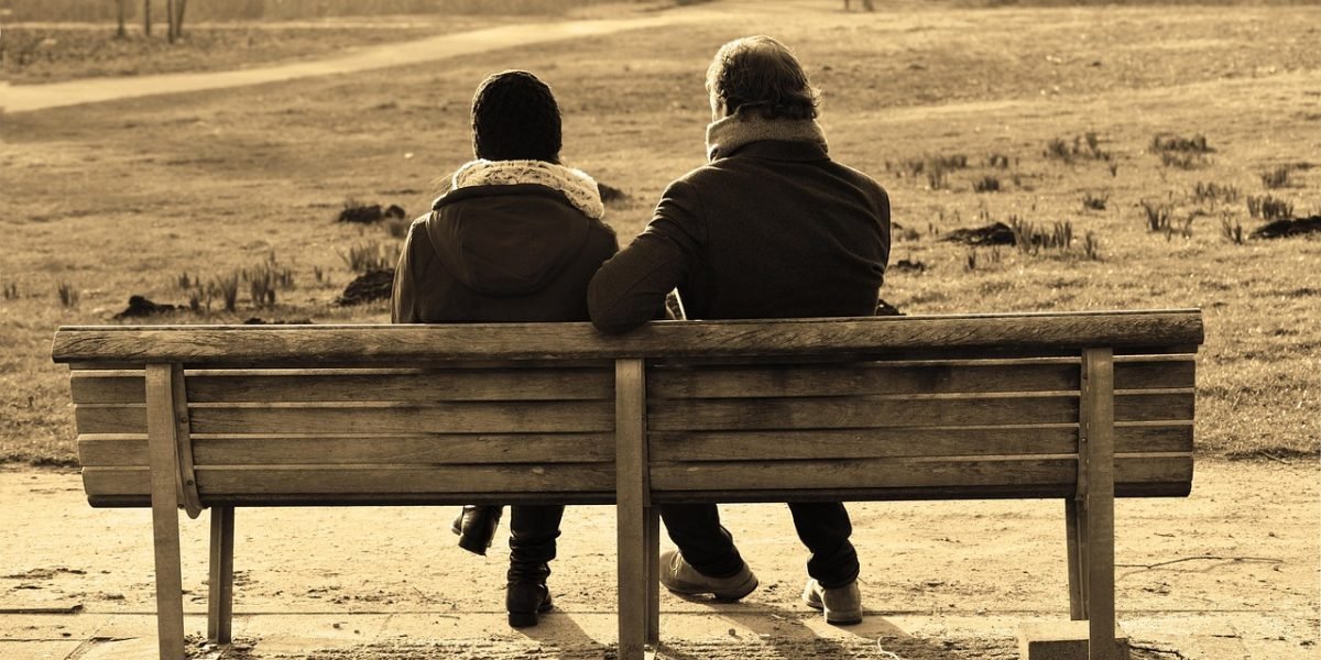 A couple engages in a serious, heartfelt conversation with a therapist, demonstrating the guided process of uncovering negative cycles and deeper emotions in EFT.