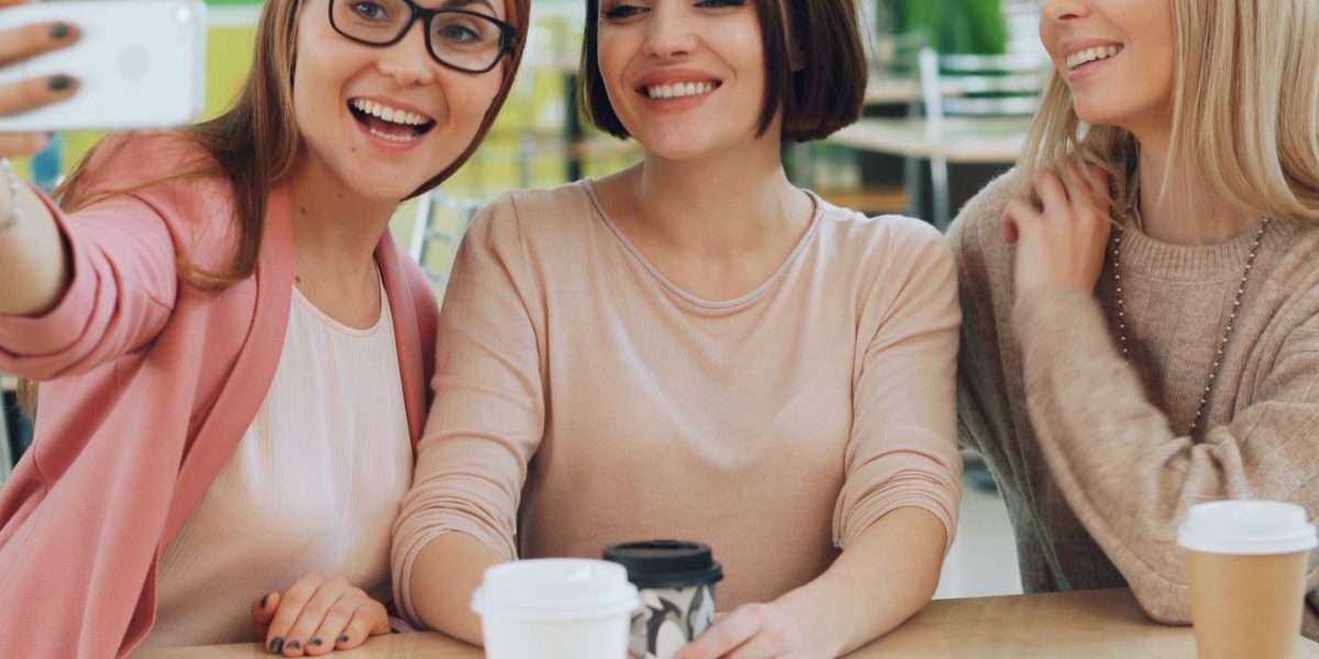Friends sharing a genuine laugh over coffee, illustrating the positive neurological and emotional benefits of social connection.