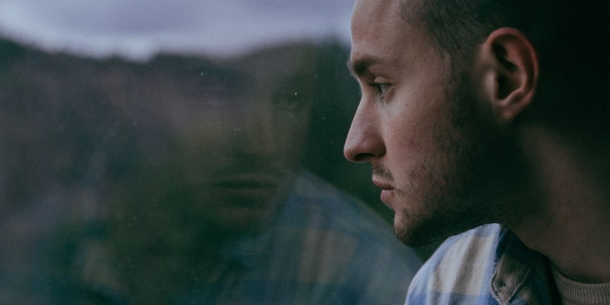 A man in a moment of quiet reflection, illustrating the widespread experience of loneliness.