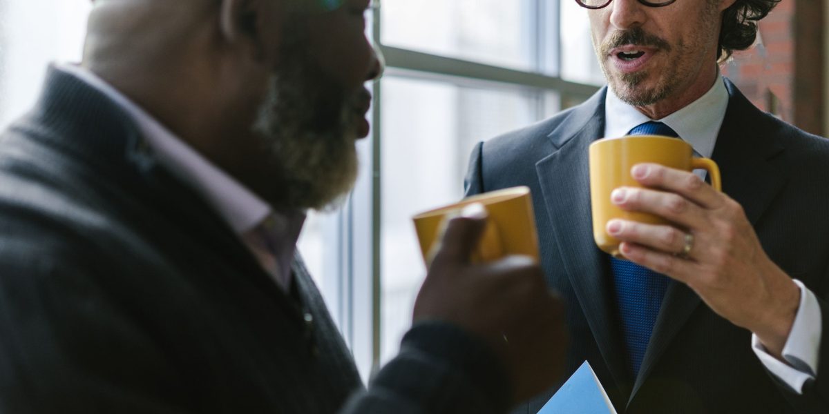 Two men having an honest conversation over coffee, depicting a regular friendship check-in.
