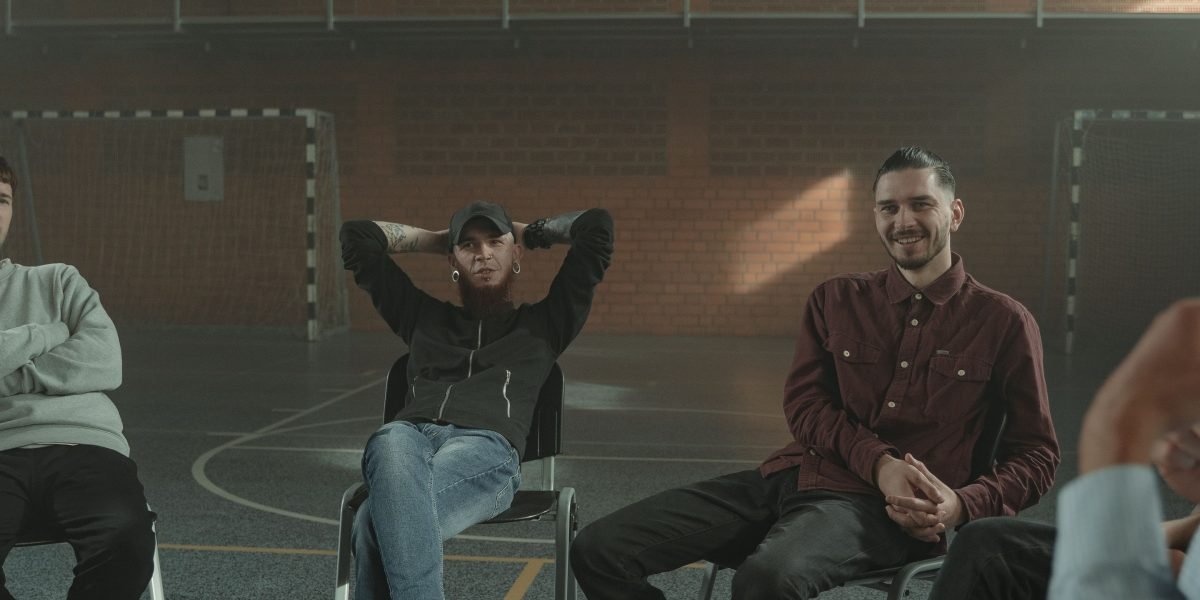 Men connecting and sharing experiences in a supportive group therapy setting.